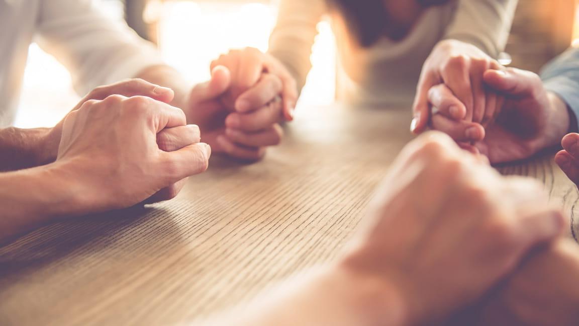 close up of friends holding hands in a circle