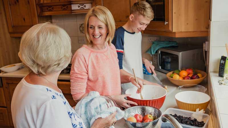 Three generations cooking together in kitchen