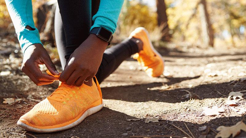 Female African American runner tying sneaker