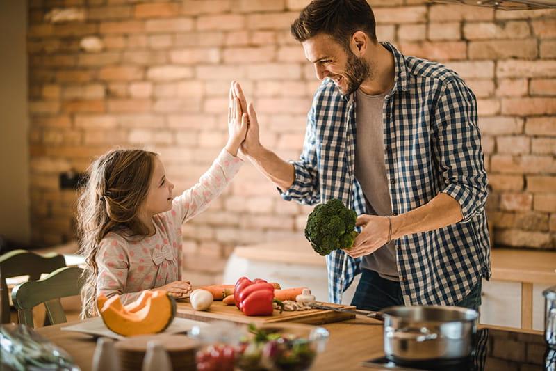 father holding 西兰花 high-five daughter